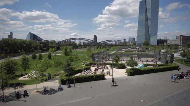 A panoramic time-lapse of a Frankfurt city park summer activity. The European Central Bank skyscraper stands in the background.