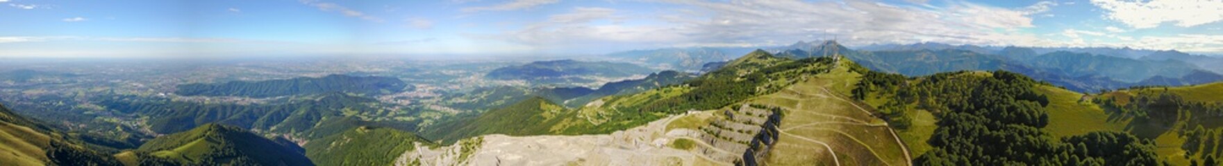 Fototapeta premium Great landscape on the Padana plain in summer time and the concrete quarry. Panorama from Linzone Mountain, Bergamo, Italy. 