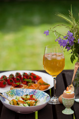 Fresh Summer Outdoor Romantic Breakfast in Park with Eggs, Berries, Flowers