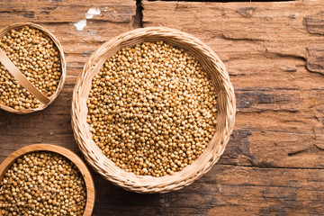Coriander seeds on a wood background