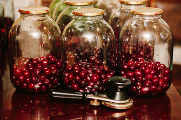 Old machine for rolling metal caps during storage. Preservation of compote from berries