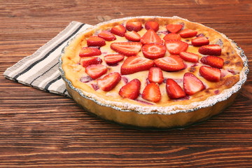 Tart with fresh strawberry on wooden background