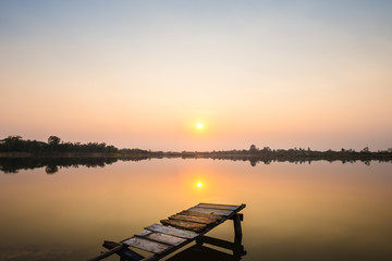 wooden bridge at the lake on sunset