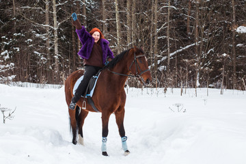 Fototapeta premium Woman with red hair and big horse outdoor in winter