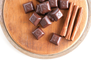 Chocolate pieces and cinnamon on a wooden cutting board
