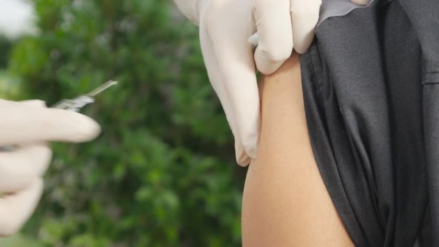 4k video of doctor injecting flu vaccine to patient's arm
