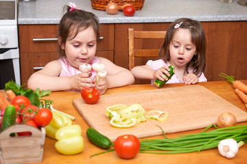 Children at the table with with fresh fruits and vegetables, home kitchen interior, healthy food concept