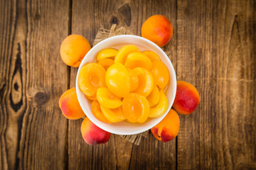 Preserved Apricots on wooden background (selective focus)