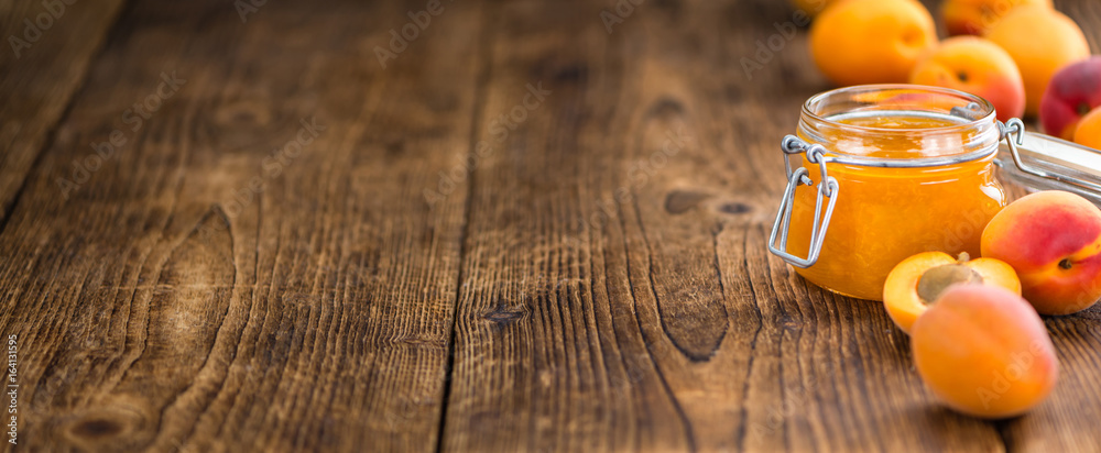 Wall mural portion of apricot jam on wooden background (selective focus)