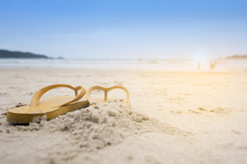 Summer holiday on the beach yellow sandals on the beach have sunset