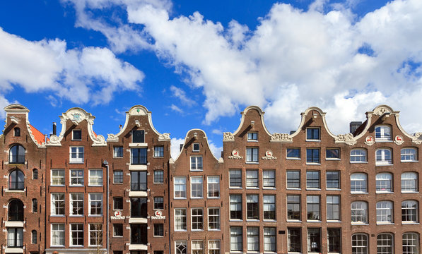 Beautiful dutch canal houses at the prinsengracht in Amsterdam, the Netherlands, with a blue sky and a nice cloudscape