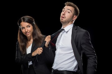 attractive businesswoman flirting with her handsome colleague, isolated on black