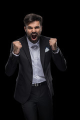 handsome excited businessman celebrating success, isolated on black