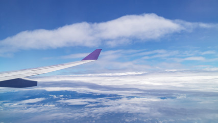 beautiful cloudy blue sky and airplane wing, aerial view from airplane window, filter effect