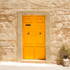 Fototapeta premium Yellow entrance door to the house in the Island of Malta.
