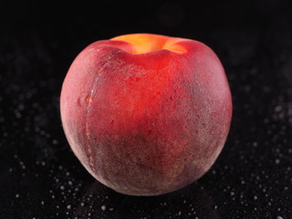 Peach on a dark background with droplets