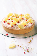 Coconut Tart with Guava Topping Cream and Pineapple Slices, on transparent glass board, on white wooden background.