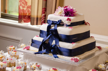 A beautiful sweet creamy Wedding cake with beautiful flowers and decorations, shot with a shallow depth of field.