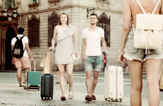  guy and girl  with suitcases walking in the  city