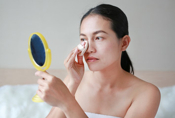 Obraz na płótnie Canvas Beauty asian woman applying makeup with Sponge Powder Puff. Woman make up herself.
