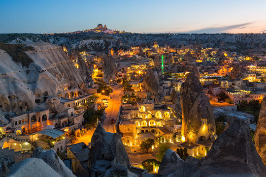 Ancient town and a castle of Uchisar dug from a mountains after twilight.