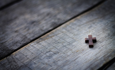 Wooden cross on wood background.