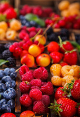 Various fresh summer Berries on the Gray Background. Mix in vintage wooden box.Food or Healthy diet concept.Super Food.Vegetarian.selective focus.