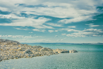 Fototapeta na wymiar white stones on shore of lake at sunny day 