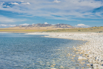 white stones on shore of lake at sunny day 
