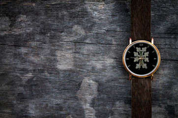 Wristwatch on wooden table.