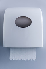 close up view of paper towel dispenser made of white plastic on wall