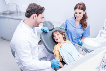 dentists preparing little boy for examining teeth in dental hospital