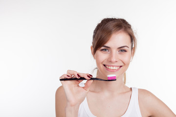 girl holding a toothbrush smiles