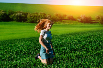 Fototapeta na wymiar Young beautiful woman running on a green field
