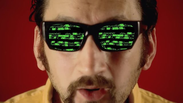A funny ugly man with hypnotic glasses, looking at random distorted characters (the source code of a bizarre computer program).
