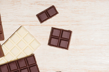 A lot of variety chocolates bar in box on white wooden background