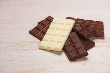 A lot of variety chocolates bar in box on white wooden background