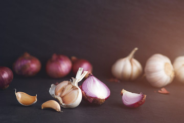 Garlic and onion on the black stone table