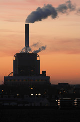 Smoking cole power factory at sunset