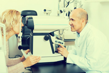 Optician doing eye check up to woman
