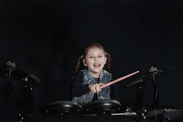 Fototapeta na wymiar Little caucasian girl drummer laughting