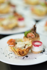 Many plates of appetizers being prepared in commercial kitchen, for an event