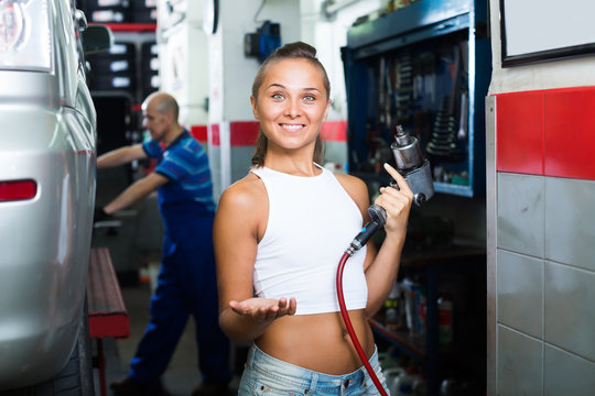 Happy woman working in car workshop