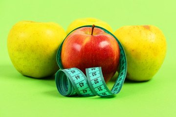 Composition of four apples and tape for measuring