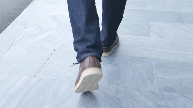 4k video of Walking on the floor, close-up view of man's leather shoes