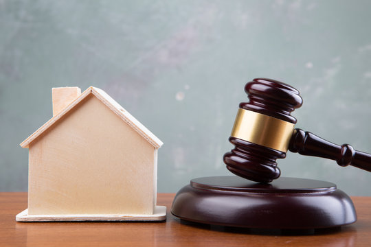 Real estate sale auction concept - gavel and house model on the wooden table