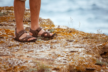 SANDALS ON ROCK NEAR THE SEA