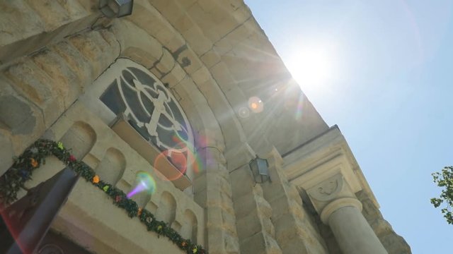 View from the bottom of church fasad on the blue sky with sunshine background.