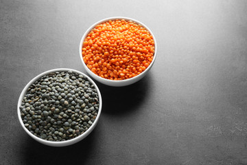Bowls with red and black lentils on table