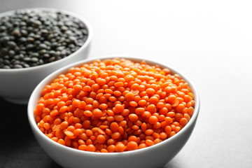 Bowls with red and black lentils on table